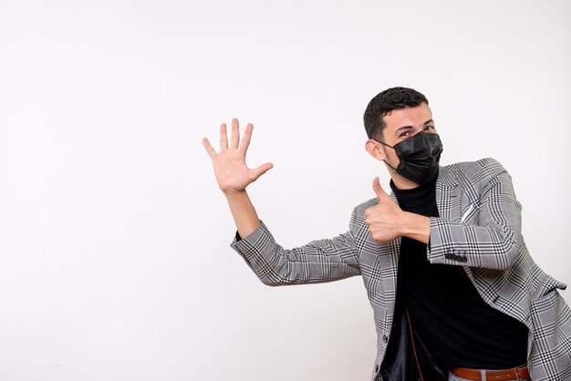 Vista frontal hombre guapo en traje haciendo pulgar arriba signo de pie sobre fondo blanco.