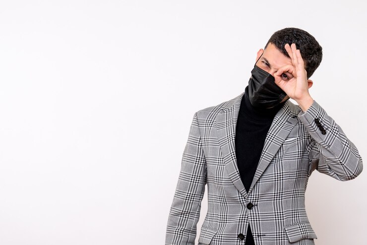 Foto gratuito vista frontal hombre guapo en traje poniendo signo okey delante de su ojo de pie sobre fondo blanco aislado