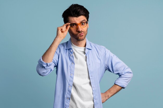 Vista frontal del hombre inteligente aferrándose a sus gafas