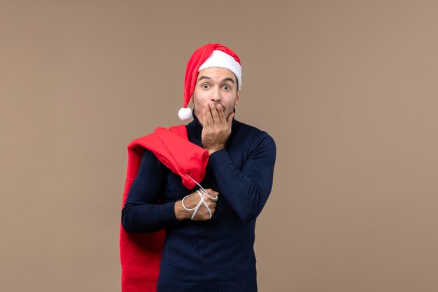 Vista frontal del hombre joven con bolsa presente, emoción vacaciones navidad