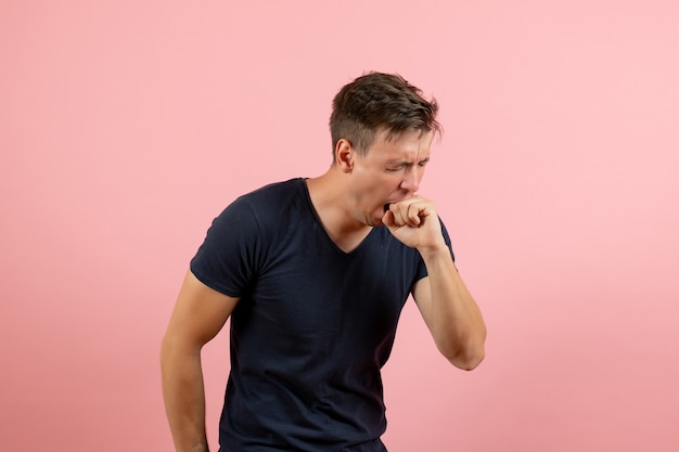 Vista frontal hombre joven en camisa azul oscuro tosiendo sobre fondo rosa emoción de modelo de hombre de color humano masculino