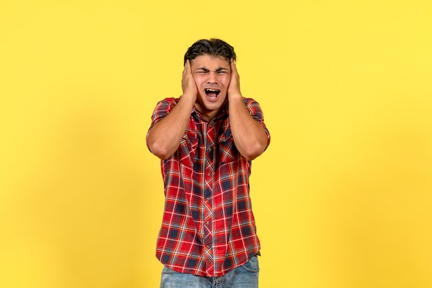 Vista frontal hombre joven en camisa brillante con cara de perdón en modelo masculino de color de fondo amarillo