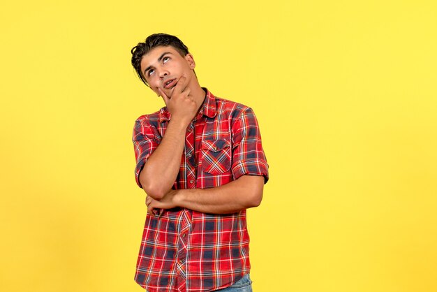 Vista frontal del hombre joven en camisa brillante pensando en el modelo masculino de color de fondo amarillo