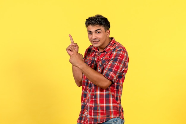 Vista frontal hombre joven en camisa brillante posando sobre fondo amarillo claro modelo masculino de color