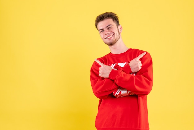 Vista frontal del hombre joven en camisa roja con regalo de Navidad