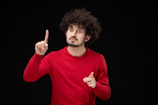 Foto gratuita vista frontal del hombre joven en camisa roja sobre pared negra