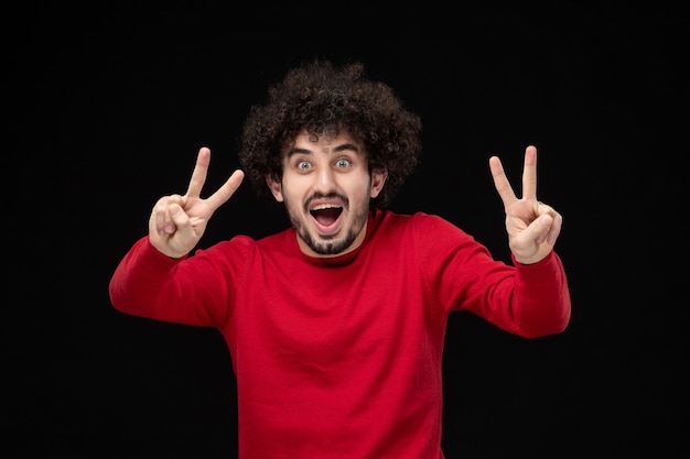 Foto gratuita vista frontal del hombre joven en camisa roja sobre pared negra