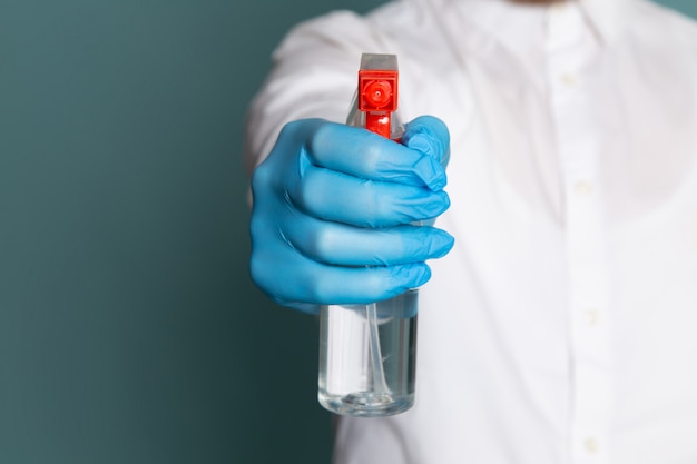 Una vista frontal hombre joven en camiseta blanca con spray sobre el azul dsesk