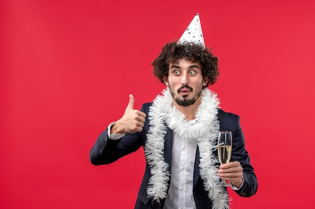 Foto gratuita vista frontal del hombre joven celebrando otro año en la pared roja fiesta humana