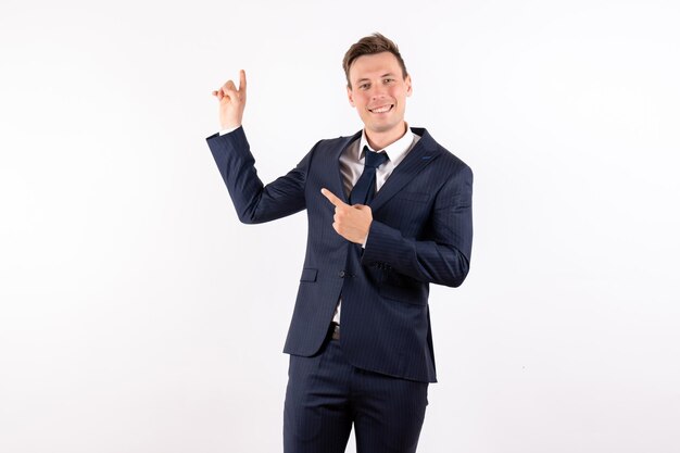 Vista frontal del hombre joven en elegante traje clásico sonriendo sobre fondo blanco.