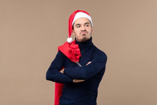 Vista frontal del hombre joven con expresión de disgusto, vacaciones de navidad santa