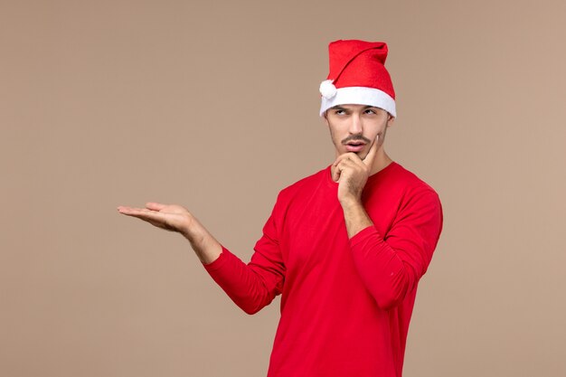 Vista frontal hombre joven con expresión de pensamiento sobre fondo marrón emoción de color de vacaciones masculinas