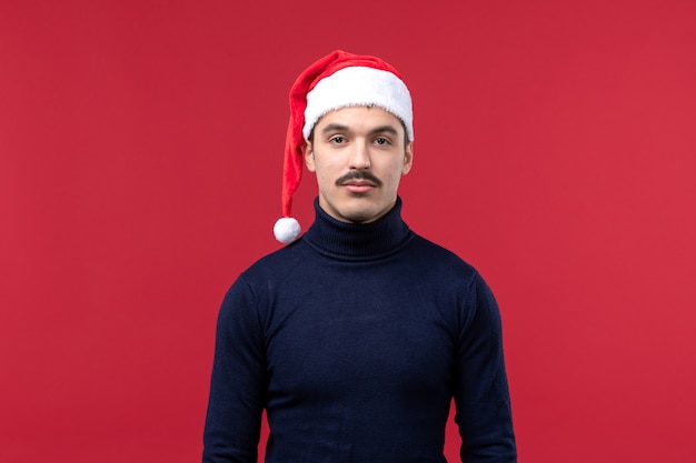 Foto gratuita vista frontal del hombre joven con expresión tranquila sobre fondo rojo.