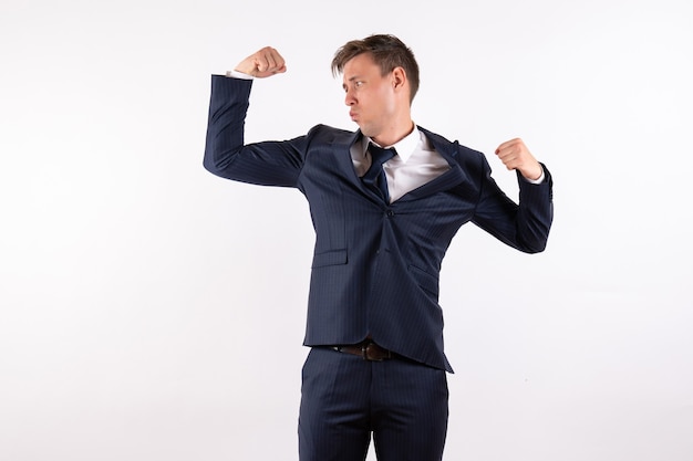 Vista frontal hombre joven flexionando en traje clásico estricto sobre fondo blanco emociones modelo de moda traje masculino humano