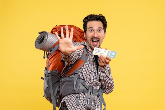 Foto gratuita vista frontal del hombre joven con mochila con boleto en amarillo