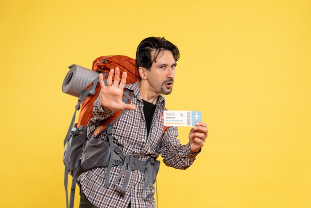 Foto gratuita vista frontal del hombre joven con mochila con boleto en amarillo