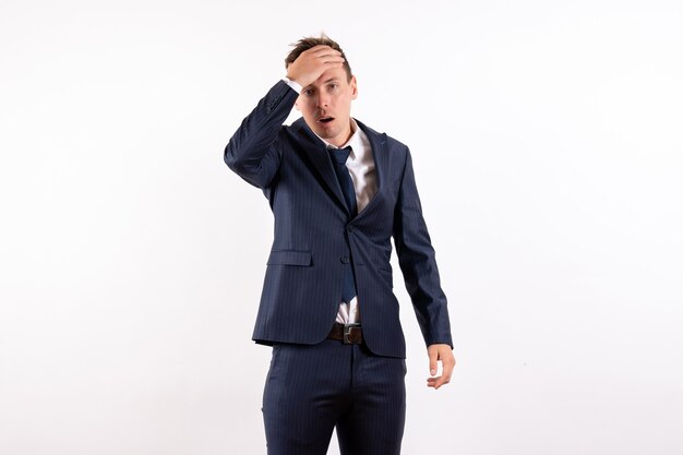 Vista frontal hombre joven que se siente nervioso en un elegante traje clásico sobre fondo blanco modelo moda masculina emoción empresarial