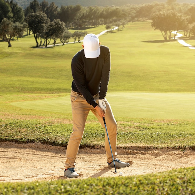 Vista frontal del hombre jugando al golf con el club