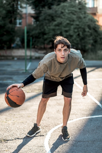 Vista frontal hombre jugando baloncesto