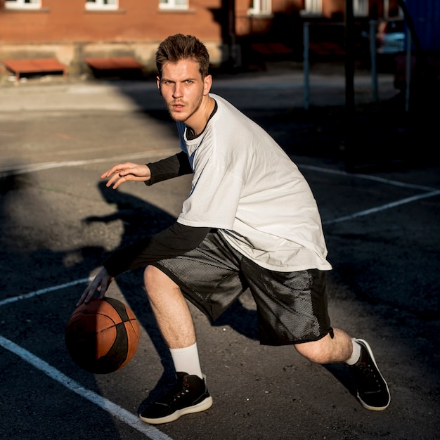 Vista frontal hombre jugando baloncesto