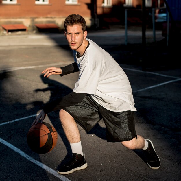 Vista frontal hombre jugando baloncesto