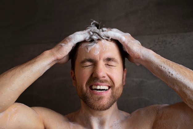 Vista frontal hombre lavando el cabello