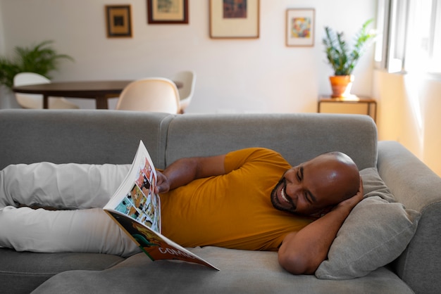 Vista frontal hombre leyendo cómics en casa