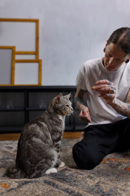 Vista frontal hombre con lindo gato en casa