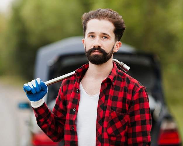 Foto gratuita vista frontal del hombre con llave de neumático