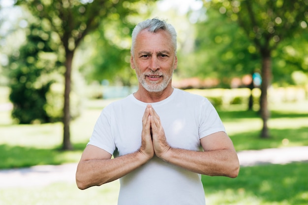 Vista frontal del hombre con las manos en posición de meditación