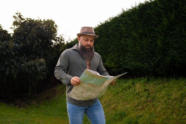 Foto gratuita vista frontal hombre con mapa al aire libre