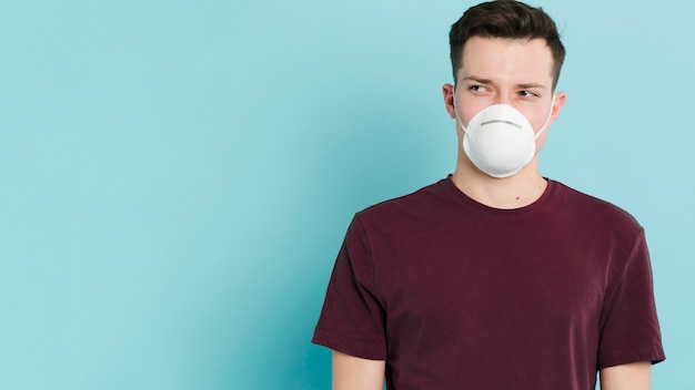 Foto gratuita vista frontal del hombre con máscara médica posando con espacio de copia