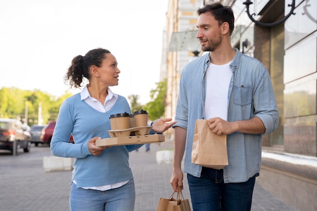 Vista frontal del hombre y la mujer al aire libre con comida para llevar