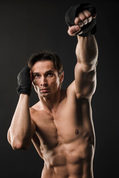 Vista frontal del hombre musculoso sin camisa con guantes de boxeo