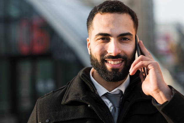 Vista frontal del hombre de negocios hablando por teléfono