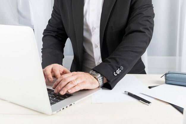 Vista frontal del hombre de negocios trabajando en su computadora portátil