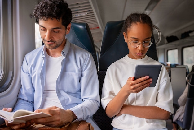 Foto gratuita vista frontal hombre y niña viajando en tren