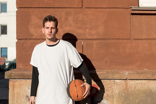 Vista frontal hombre con una pelota de baloncesto