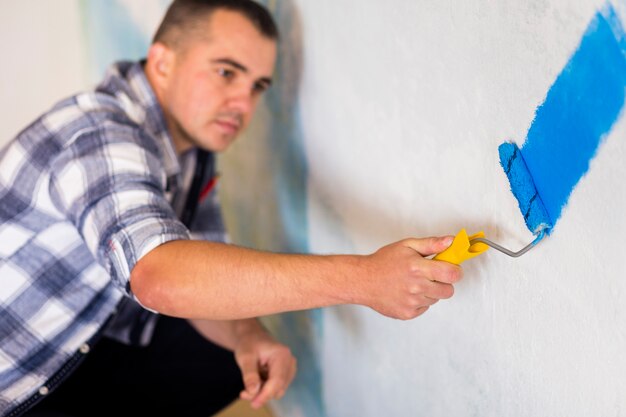 Vista frontal del hombre pintando una pared