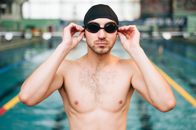 Vista frontal hombre ponerse gafas de natación