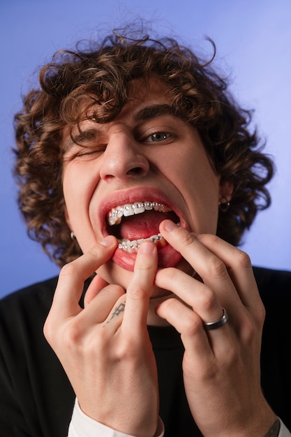 Vista frontal hombre posando con gemas dentales