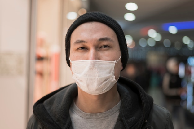 Vista frontal del hombre posando con una máscara médica