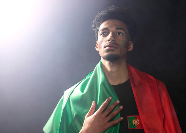 Foto gratuita vista frontal del hombre que llevaba la bandera de portugal