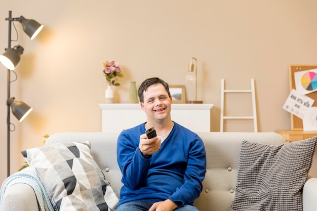 Foto gratuita vista frontal del hombre que sostiene el control remoto y ve la televisión