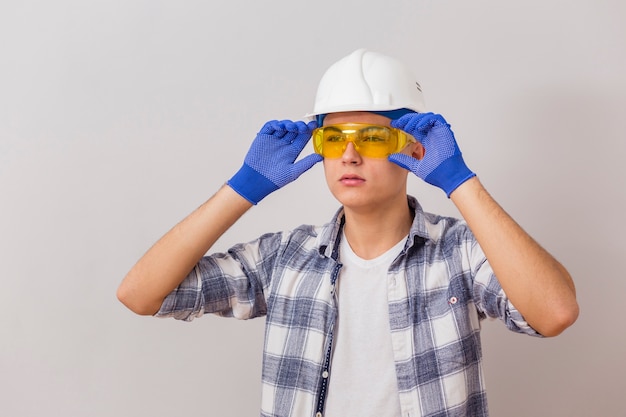 Vista frontal del hombre que sostiene sus gafas de protección