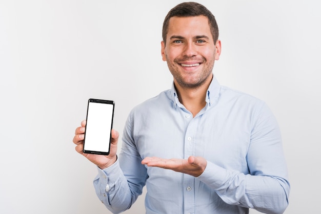 Vista frontal del hombre que sostiene un teléfono inteligente