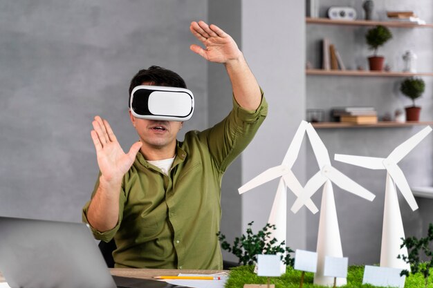 Vista frontal del hombre que trabaja en un proyecto de energía eólica ecológica y que utiliza un casco de realidad virtual