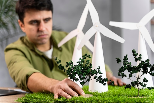 Vista frontal del hombre que trabaja en un proyecto de energía eólica ecológica con turbinas eólicas