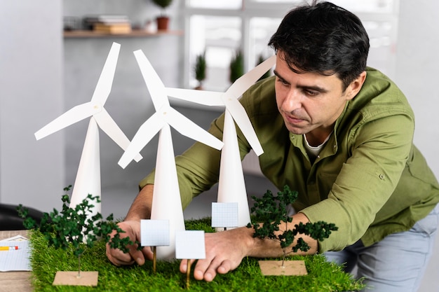 Vista frontal del hombre que trabaja en un proyecto de energía eólica ecológica con turbinas eólicas