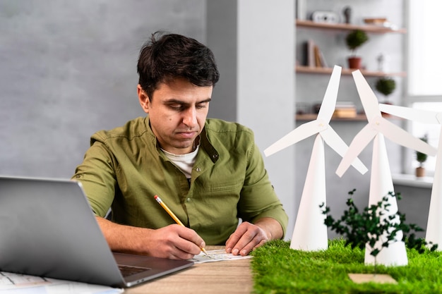 Foto gratuita vista frontal del hombre que trabaja en un proyecto de energía eólica ecológica